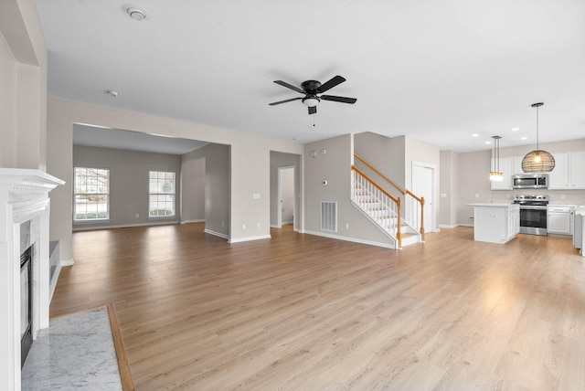 unfurnished living room featuring ceiling fan and light hardwood / wood-style flooring