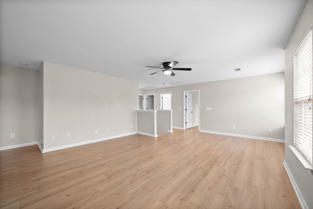 unfurnished living room featuring ceiling fan, a wealth of natural light, and light wood-type flooring