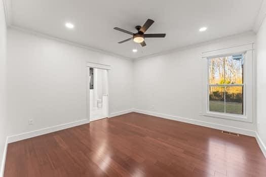 spare room featuring baseboards, a ceiling fan, ornamental molding, dark wood-type flooring, and recessed lighting