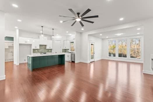 kitchen featuring dark wood-type flooring, white cabinetry, backsplash, a center island, and decorative light fixtures