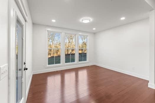 spare room featuring baseboards, wood finished floors, and recessed lighting