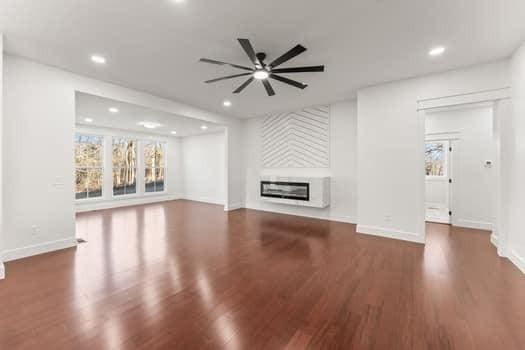 unfurnished living room with a glass covered fireplace, recessed lighting, and wood finished floors