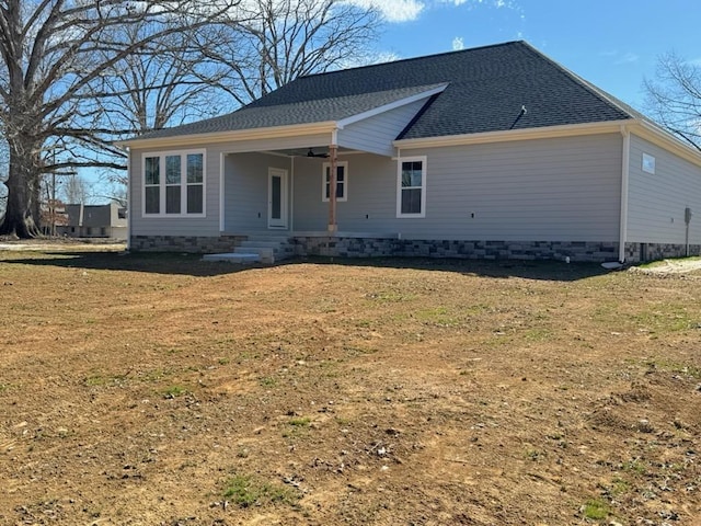 view of front of house with roof with shingles and a front yard