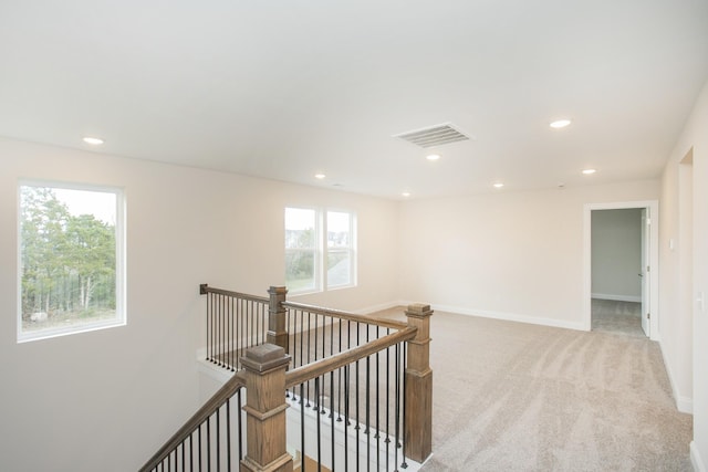 hall featuring light colored carpet