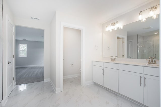 bathroom featuring vanity, toilet, and a shower with shower door