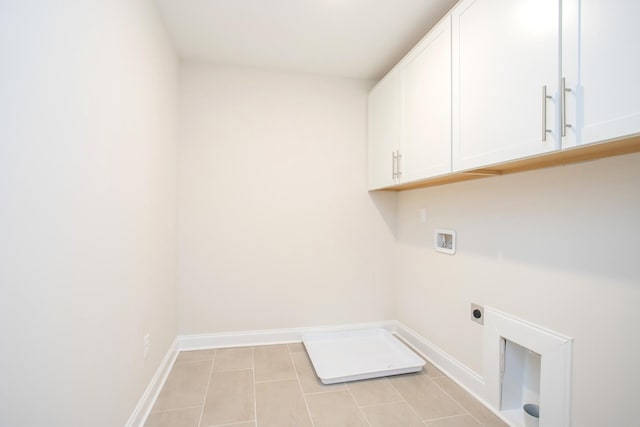 clothes washing area with cabinets, electric dryer hookup, washer hookup, and light tile patterned floors