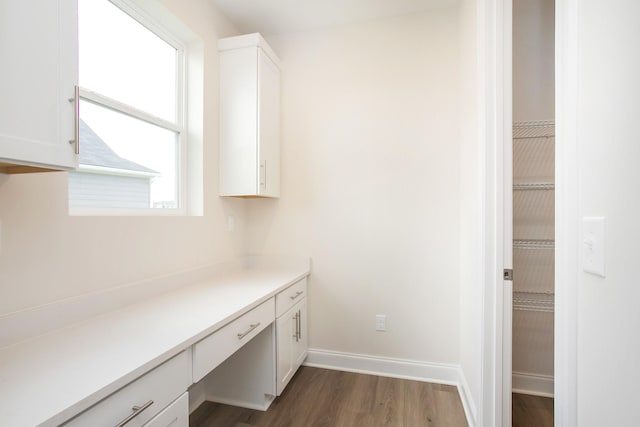 interior space with dark hardwood / wood-style flooring and built in desk