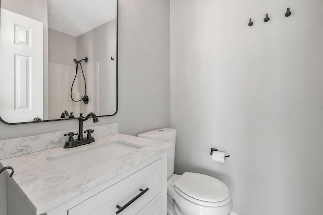 bathroom with vanity, toilet, and walk in shower