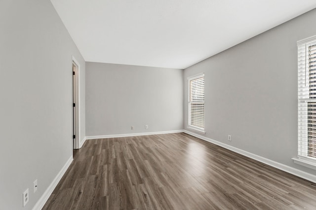 spare room with dark wood-type flooring and a healthy amount of sunlight