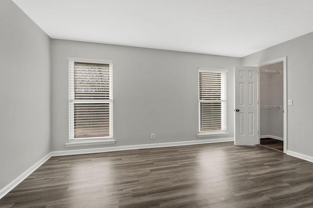 spare room featuring a healthy amount of sunlight and dark hardwood / wood-style floors