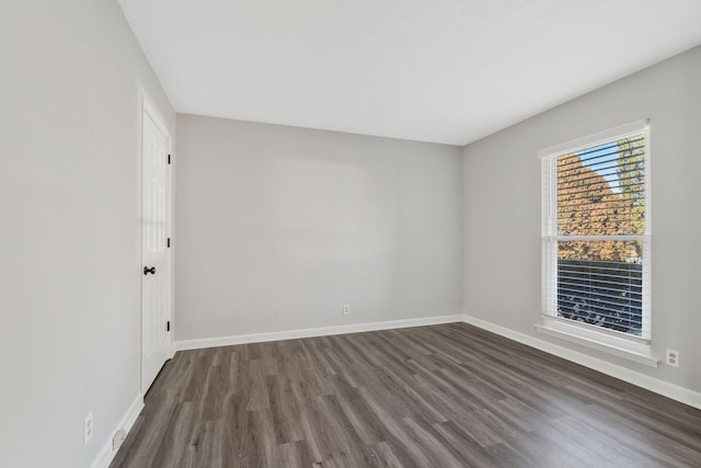 spare room with dark wood-type flooring