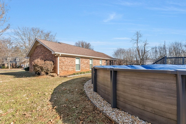 view of side of property with a covered pool and a yard