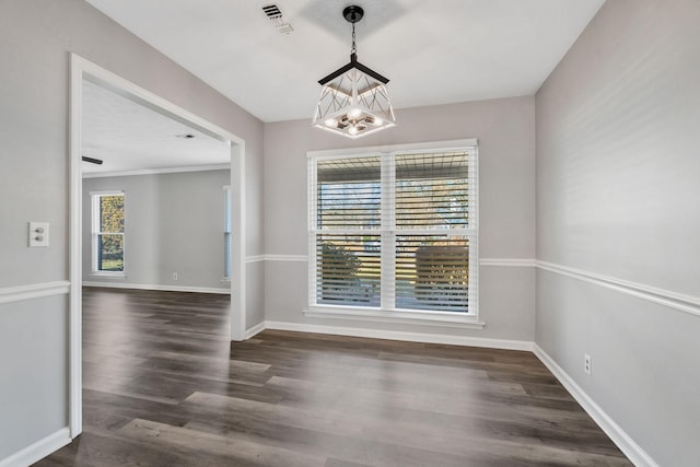 unfurnished dining area featuring dark wood-type flooring and an inviting chandelier