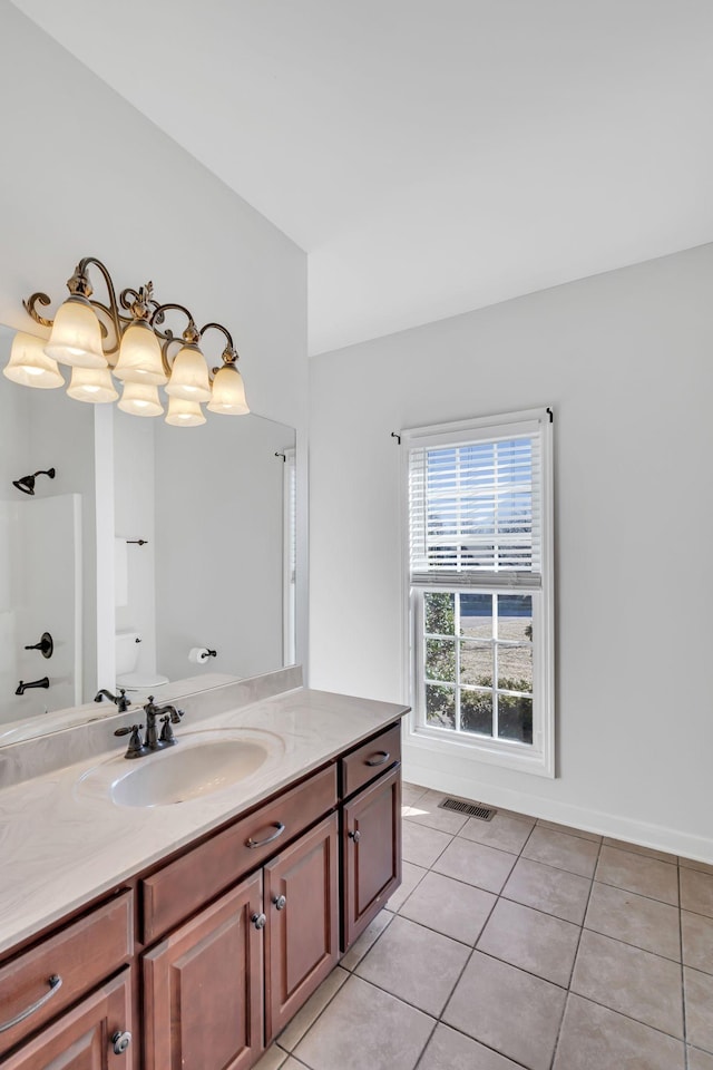 bathroom featuring tile patterned flooring, vanity, a shower, and a chandelier