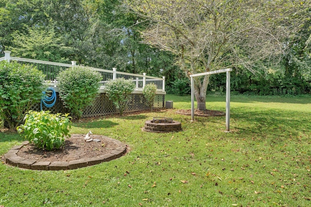 view of yard featuring a wooden deck and a fire pit