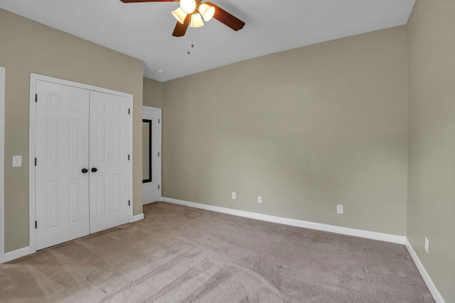 unfurnished bedroom with light colored carpet, ceiling fan, and a closet