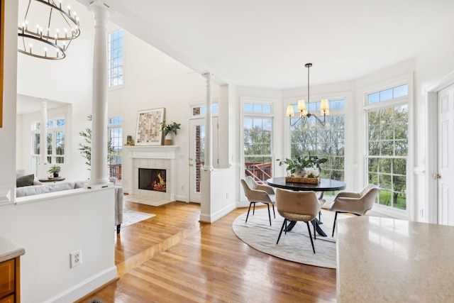 dining room featuring wood-type flooring, a chandelier, and ornate columns