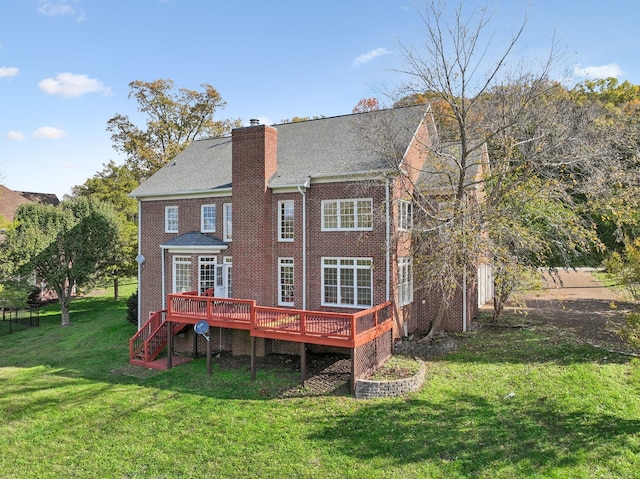 back of property featuring a wooden deck and a lawn