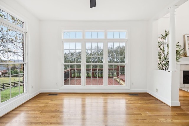 interior space with ceiling fan, a fireplace, and light wood-type flooring