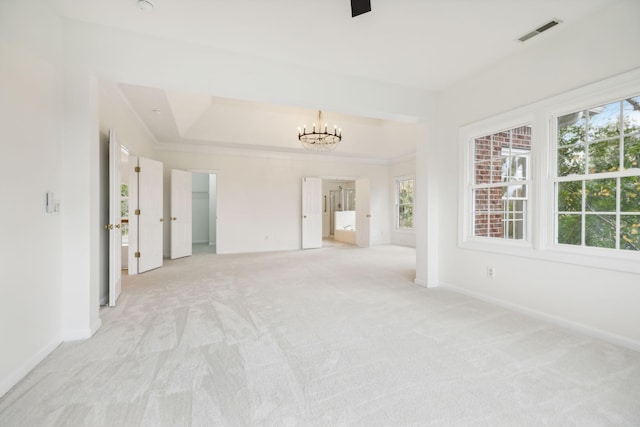 carpeted spare room with crown molding and a chandelier