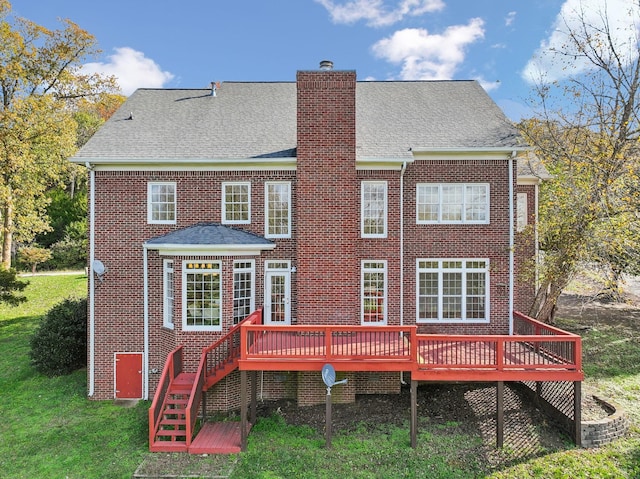 rear view of house featuring a wooden deck and a yard