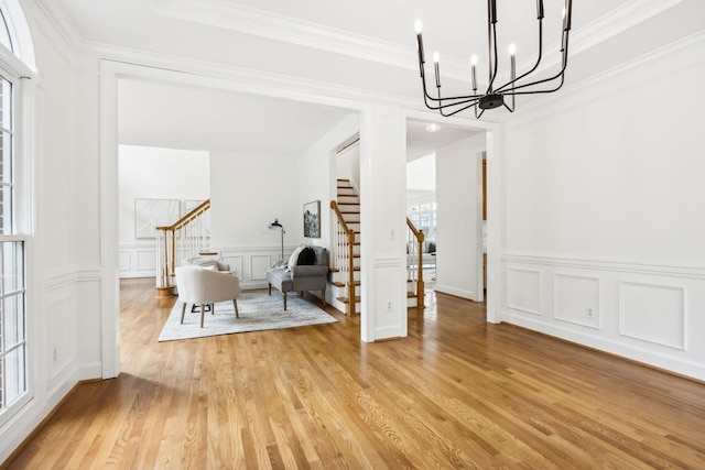 dining space featuring a notable chandelier, crown molding, light hardwood / wood-style flooring, and a healthy amount of sunlight