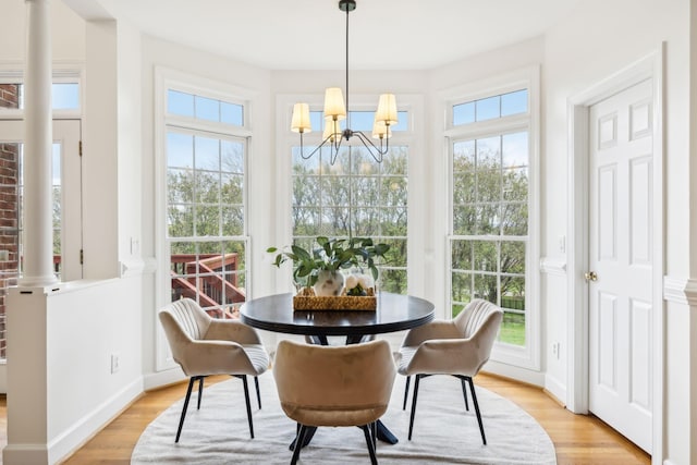 dining space with a notable chandelier and light hardwood / wood-style floors