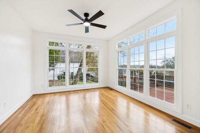 unfurnished sunroom featuring a wealth of natural light and ceiling fan