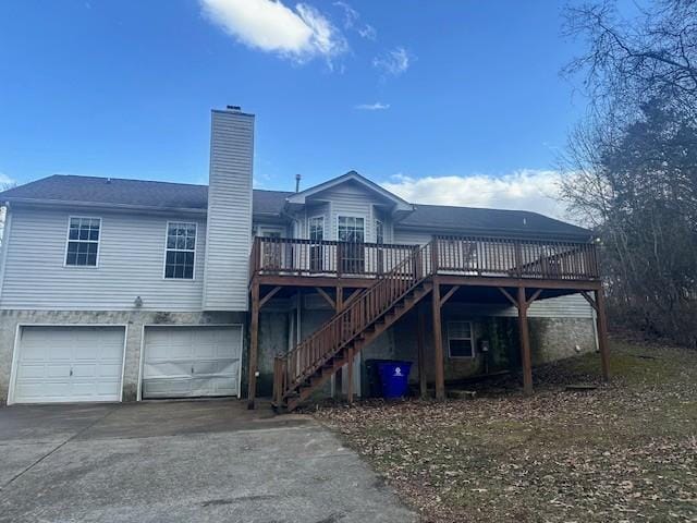 rear view of house featuring a garage and a deck