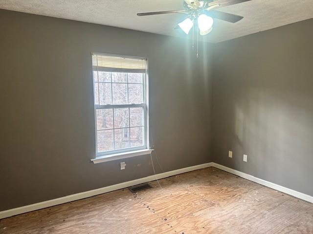 empty room featuring ceiling fan and a textured ceiling