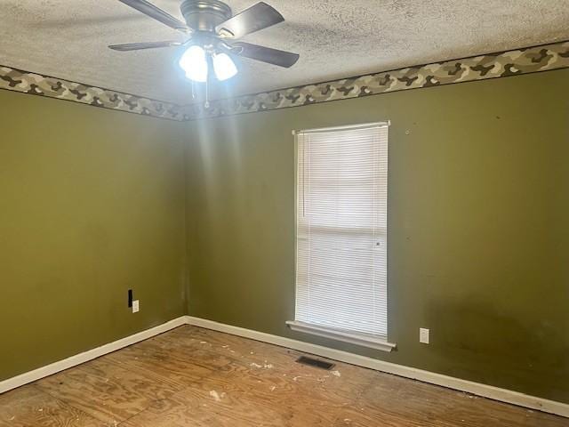 unfurnished room with ceiling fan and a textured ceiling