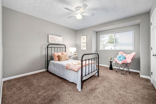 bedroom with ceiling fan, carpet flooring, and a textured ceiling