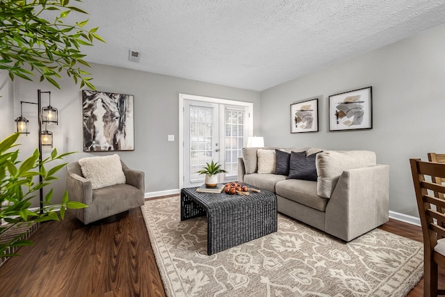 living room featuring hardwood / wood-style flooring, a textured ceiling, and french doors