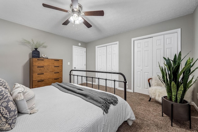 bedroom featuring multiple closets, ceiling fan, carpet flooring, and a textured ceiling