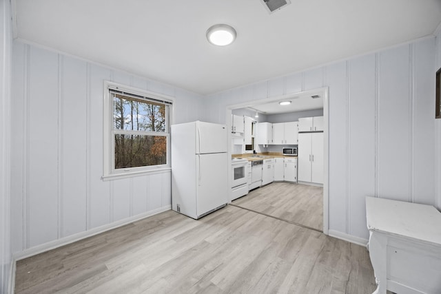 kitchen featuring white appliances, light hardwood / wood-style flooring, and white cabinets