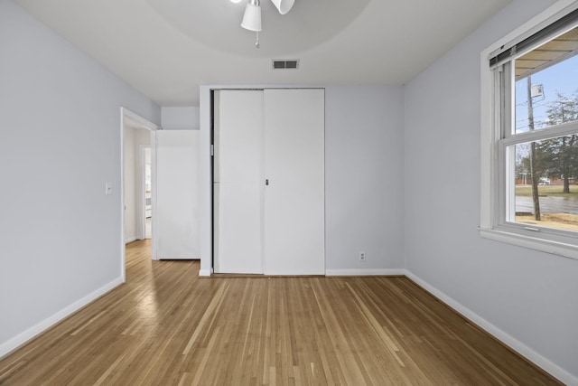 unfurnished bedroom with a closet, ceiling fan, and light wood-type flooring