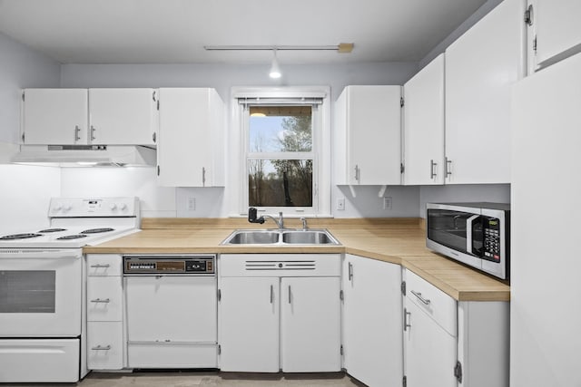 kitchen featuring rail lighting, sink, white cabinets, and white appliances