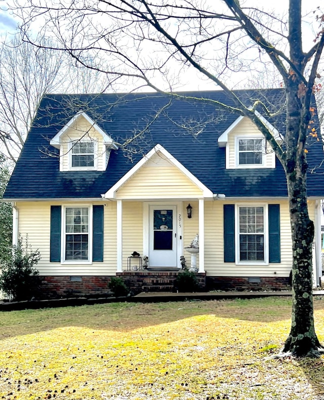 cape cod home featuring a front yard