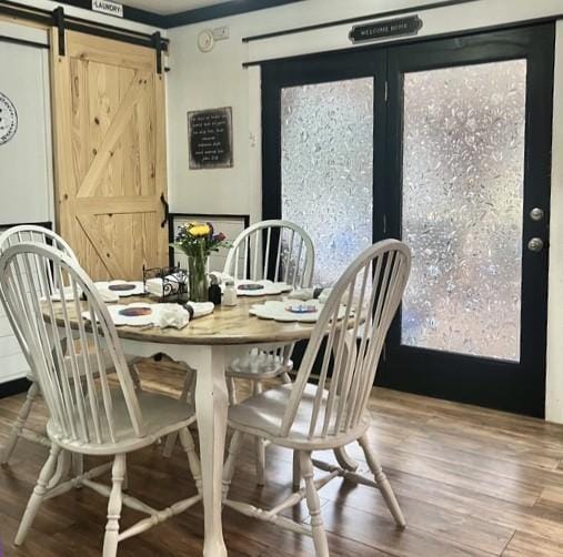 dining room with wood-type flooring and a barn door