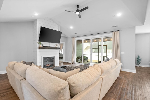 living room with a fireplace, dark hardwood / wood-style floors, ceiling fan, and vaulted ceiling