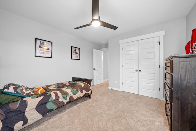 bedroom with light colored carpet, ceiling fan, and a closet