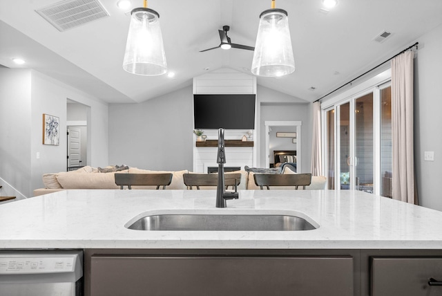 kitchen with dishwasher, a kitchen island with sink, and decorative light fixtures