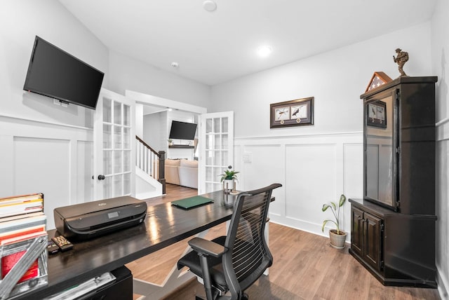 office space with light hardwood / wood-style floors and french doors