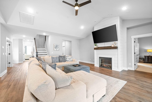 living room featuring a fireplace, wood-type flooring, high vaulted ceiling, and ceiling fan