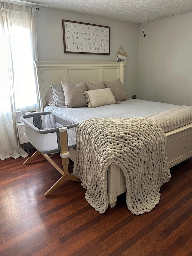 bedroom featuring dark wood-type flooring and a textured ceiling