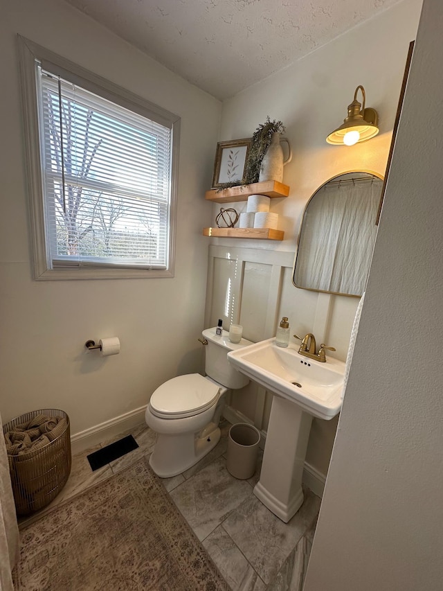 bathroom with sink, a textured ceiling, and toilet