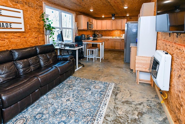 living room featuring concrete flooring, sink, and heating unit