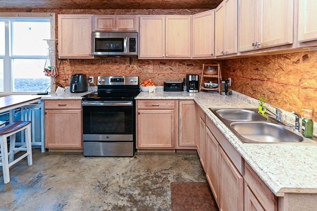 kitchen with stainless steel appliances, light brown cabinetry, sink, and decorative backsplash