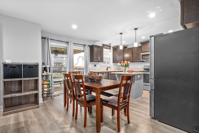 dining space featuring sink and light hardwood / wood-style flooring