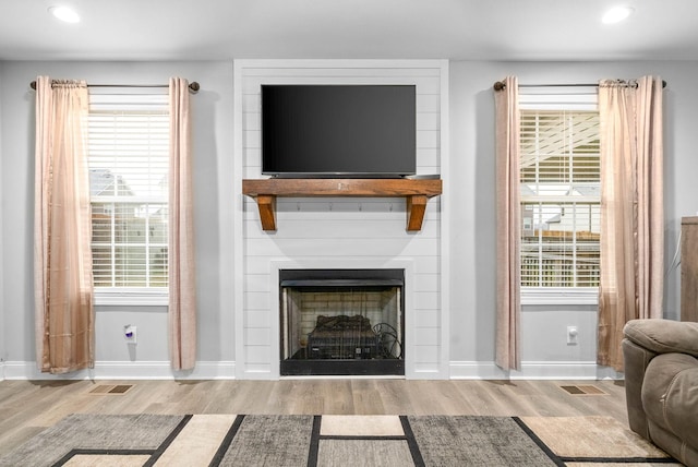 living room with a large fireplace and light hardwood / wood-style floors